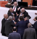 Zafer Isik, a lawmaker from president Recep Tayyip Erdogan's ruling party, rear center, punches Huseyin Ors, a lawmaker from the opposition Good Party, third left, in the face at the parliament, in Ankara, Turkey, Tuesday, Dec. 6, 2022. Ors was hospitalized on Tuesday following a brawl that broke out in Turkey's parliament during a tense debate over next year's budget. (AP Photo)