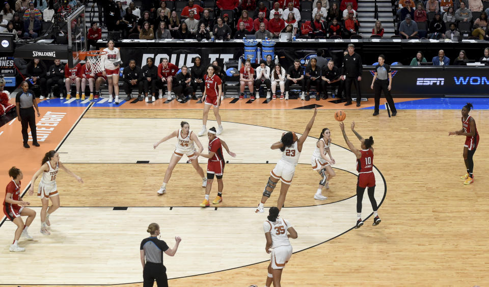 North Carolina State guard Aziaha James (10) shoots the ball over Texas forward Aaliyah Moore (23) as guard Shaylee Gonzales, center looks on from the three-point line during the second half of a Elite Eight college basketball game in the NCAA Tournament, Sunday, March 31, 2024, in Portland, Ore. (AP Photo/Steve Dykes)