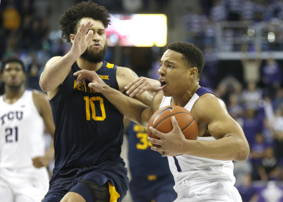 TCU guard Desmond Bane (1) is called for an offensive foul on West Virginia guard Jermaine Haley (10) during the second half of an NCAA college basketball game, Saturday, Feb. 22, 2020 in Fort Worth, Texas. TCU won in overtime. (AP Photo/Ron Jenkins)