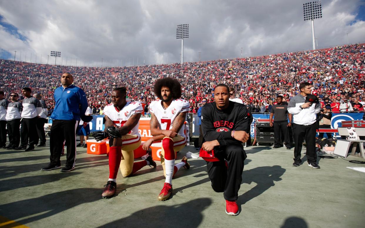  Colin Kaepernick #7 and Eric Reid #35 take a knee - Michael Zagaris/Getty Images