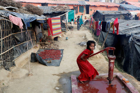 A Rohingya refugee girl plays at a tube-well in Palong Khali camp, near Cox's Bazar, Bangladesh January 14, 2018. REUTERS/Tyrone Siu