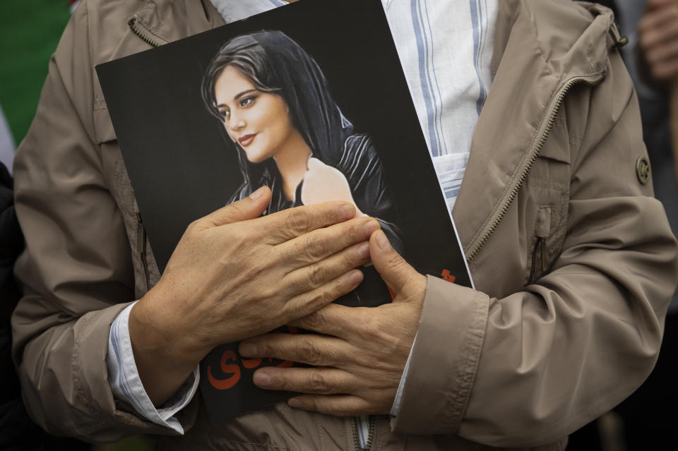 A portrait of Mahsa Amini is held during a rally calling for regime change in Iran following the death of Amini, a young woman who died after being arrested in Tehran by Iran's notorious "morality police," in Washington, Saturday, Oct. 1, 2022. (AP Photo/Cliff Owen)