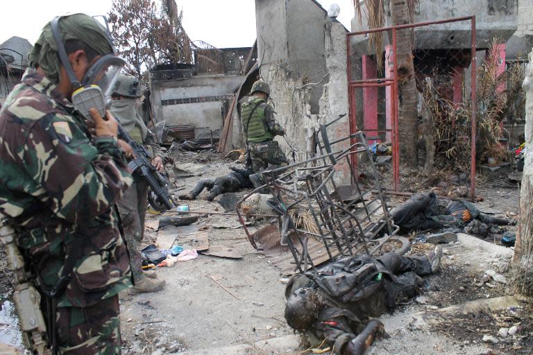 Soldiers look at bodies believed to be Muslim rebels in the Santa Catalina area of Zamboanga City on September 26, 2013