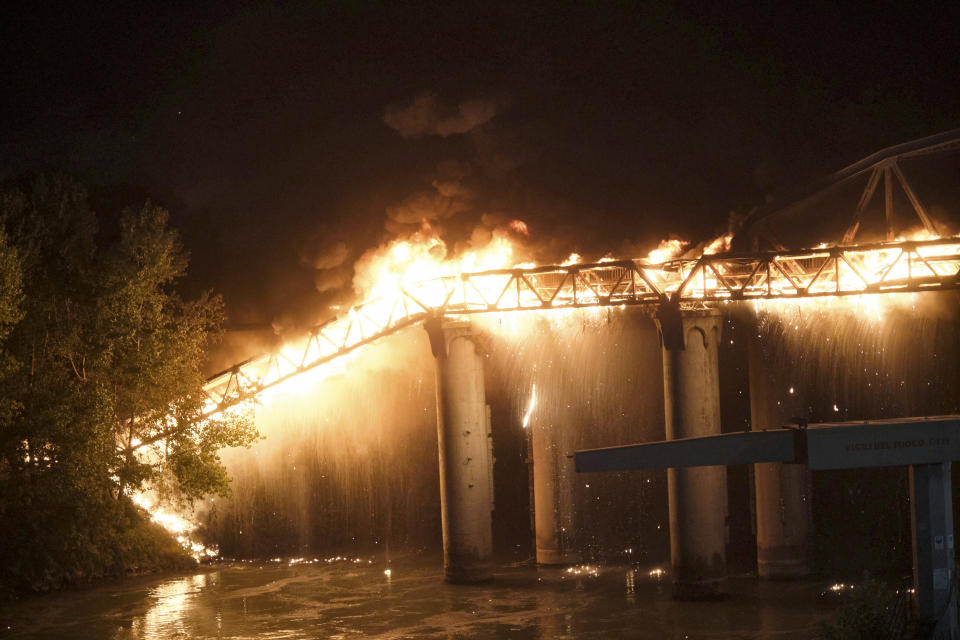 Flames engulf the Industry Bridge in Rome, early Sunday, Oct. 3, 2021. A blaze, possibly sparked by a gas canister explosion, destroyed part of an historic bridge spanning the Tiber River in Rome before firefighters extinguished the flames early Sunday. (Mauro Scrobogna/LaPresse via AP)