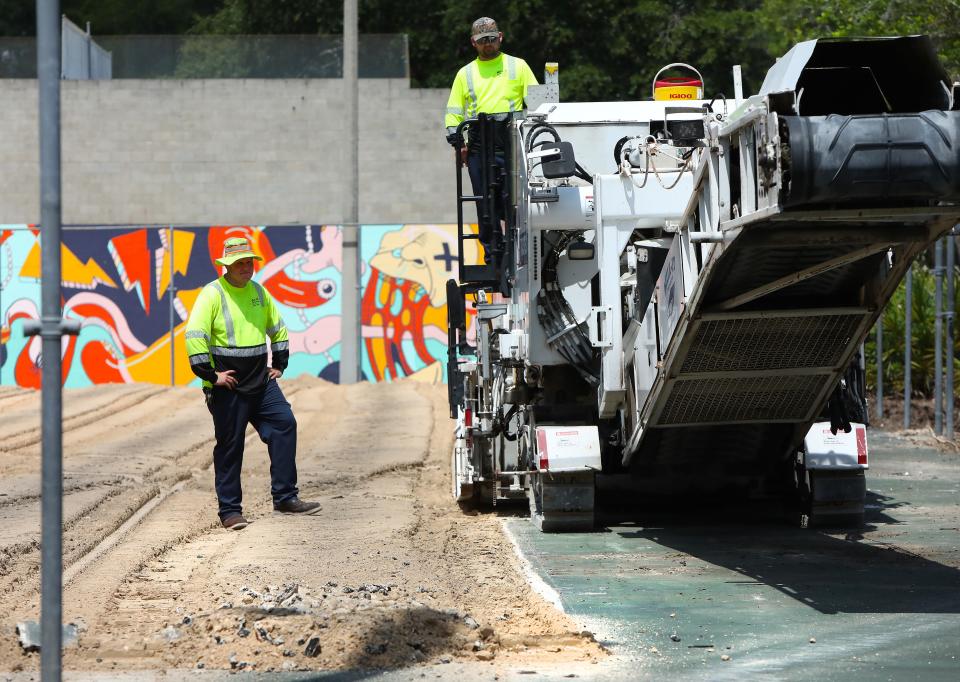 A construction crew works to tear up the surface of the tennis courts at Tom Petty Park as part of a project to reconstruct the courts at the park, in Gainesville FL. May 16, 2022. Renovations began in early May with monies from the Wild Spaces & Public Places half-cent sales tax. The tennis courts will be closed until construction is completed in August 2022.   [Brad McClenny/The Gainesville Sun] 