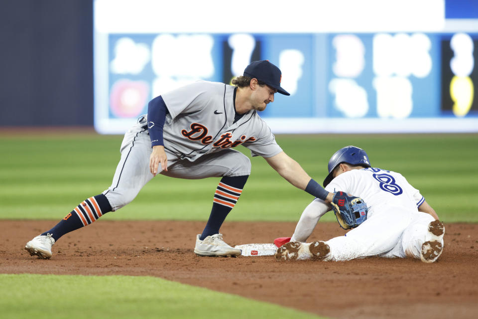 Toronto Blue Jays' Cavan Biggio (8) steals second base ahead of a tag by Detroit Tigers' Zach McKinstry, left, in third-inning baseball game action in Toronto, Thursday, April 13, 2023. (Cole Burston/The Canadian Press via AP)