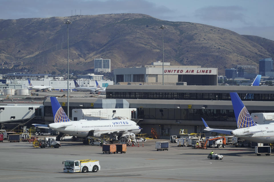 United Airlines planes are seen parked at San Francisco International Airport with a maintenance hangar in the background on Wednesday, July 14, 2021, in San Francisco. (AP Photo/Eric Risberg)