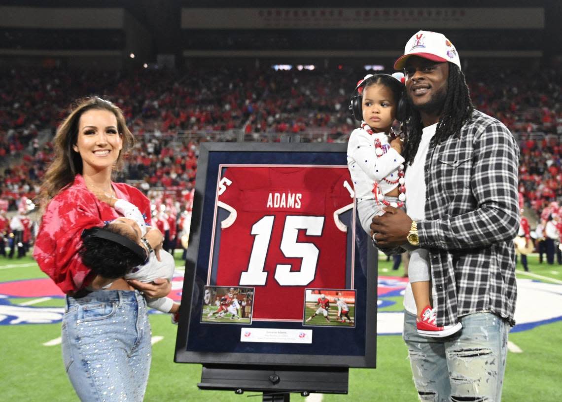 Davonte Adams, right, stands with his family and his Fresno State jersey as it is retired Saturday, Oct. 15, 2022 in Fresno.