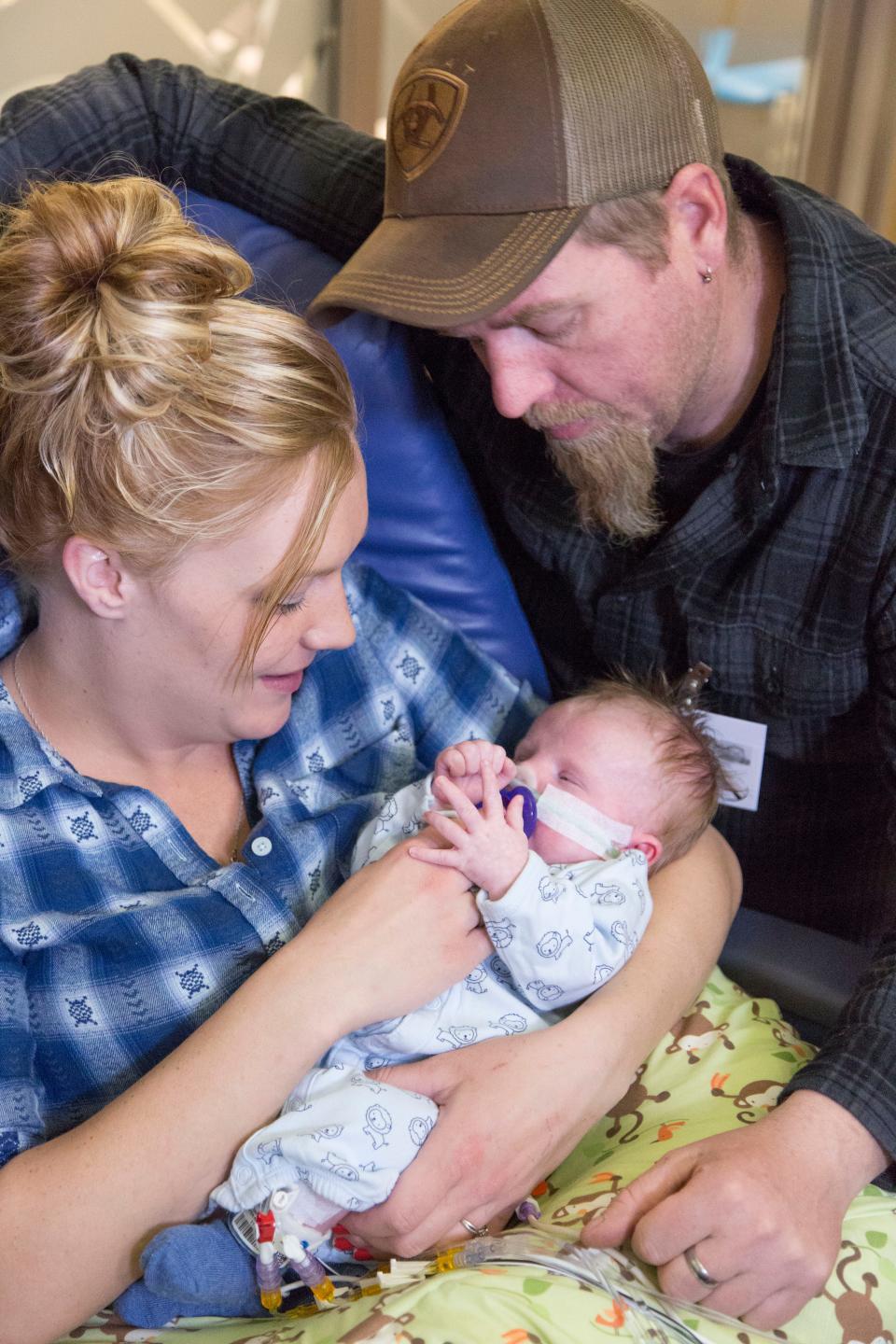 Hunter Bruton, now age 2, has CHARGE syndrome. He does not have a thymus and, consequently, no immune system. He is on Duke University's wait list to have a thymus transplant. He is pictured here in 2018 with his parents, Victoria Parker and Russell Bruton.