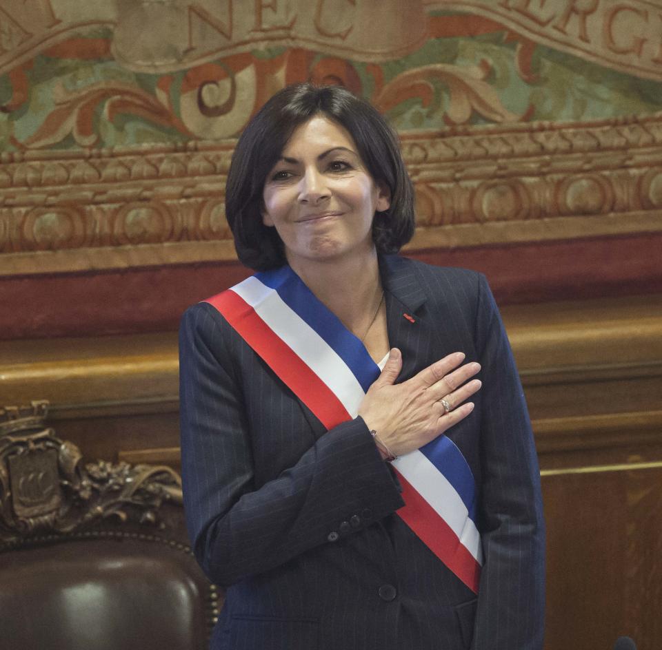 The new mayor of Paris Anne Hidalgo, wearing the mayoral sash in the color of the French Republic, acknowledges applause after her election, in Paris, Saturday, April 5, 2014. The first woman mayor of Paris has taken office, hailing a “great advance for all women” and saying she feels the weight of responsibility in her new job. (AP Photo/Michel Euler)