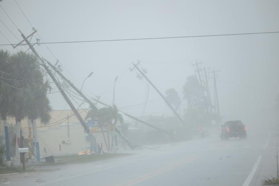 A motorist drives past broken utility poles downed by strong wind gusts as Hurricane Milton approaches Fort Myers, Florida, U.S. October 9, 2024. 