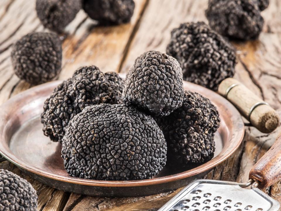 Black truffles on the plate on the old wooden table