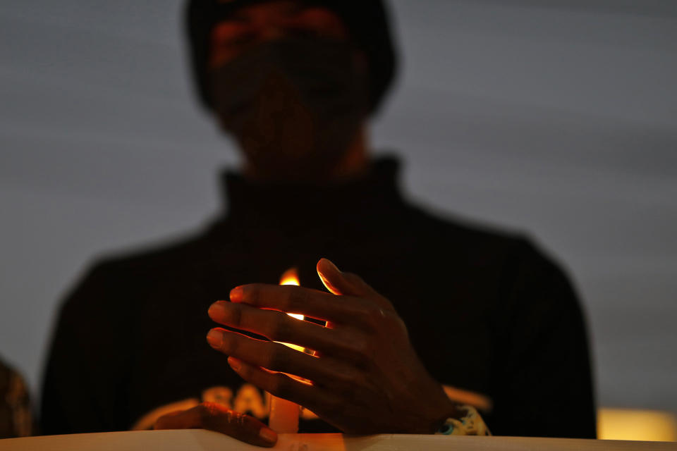 A man holds a candle during a vigil in memory of victims of a plane crash in Kathmandu, Nepal, Monday, Jan. 16, 2023. Nepal began a national day of mourning Monday as rescue workers resumed the search for six missing people a day after a plane to a tourist town crashed into a gorge while attempting to land at a newly opened airport, killing at least 66 of the 72 people aboard in the country's deadliest airplane accident in three decades. (AP Photo/Bikram Rai)