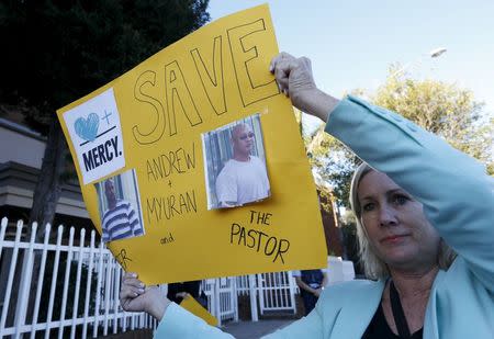 A woman holds a banner calling for a halt to the planned execution of two convicted Australian drug traffickers on death row in Indonesia, outside the Indonesian consulate in Sydney, Australia, April 27, 2015. REUTERS/Jason Reed