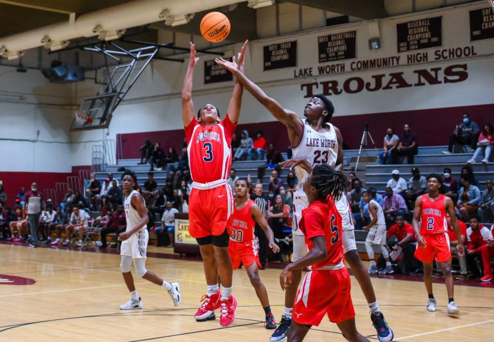 Lake Worth forward Chancellor Wilson (23) contests a rebound against Forest Hill Mario McDonnough (3) to end the first quarter during the Class 7A Region 3 semi-final game between Forest Hill and host Lake Worth in Lake Worth Beach, FL, on Tuesday, February 22, 2022. Final score, Lake Worth 78, Forest Hill, 71.