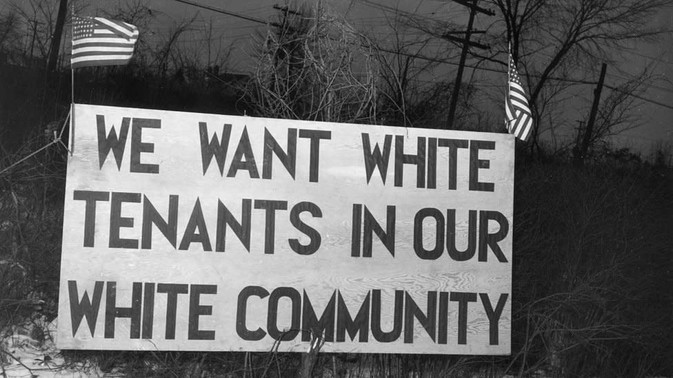 Un aviso dispuesto en Detroit (Michigan) en 1942 frente a un proyecto de vivienda social que dice "Queremos inquilinos blancos en nuestra comunidad blanca".