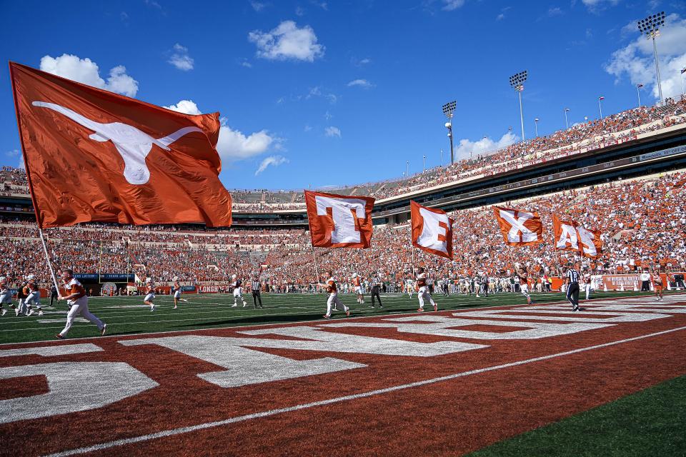 Texas cheerleaders carry flags on a run through the end zone at Royal-Memorial Stadium after a touchdown in the Longhorns' season-opening win over Colorado State on Aug. 31.