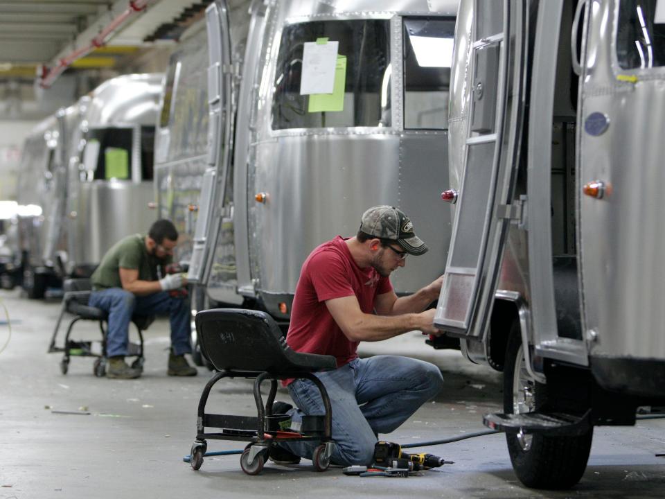 two workers working on Airstream trailers in the Airstream factory in 2014