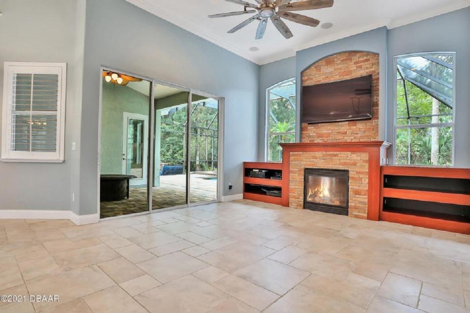 A beautiful designer fan hangs from 12-foot ceilings in the main living area, which is warmed by beautiful fireplace.