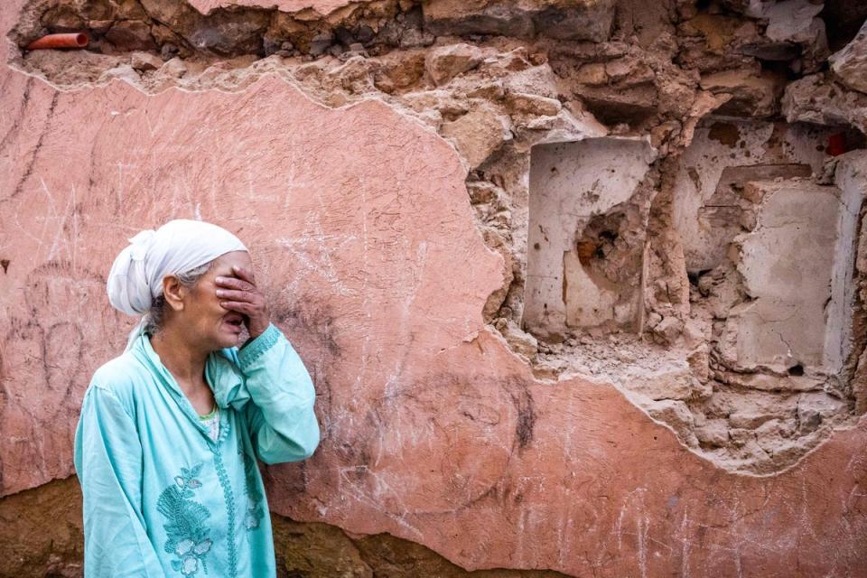 A woman in front of her earthquake-damaged house in the old city in Marrakech (AFP)