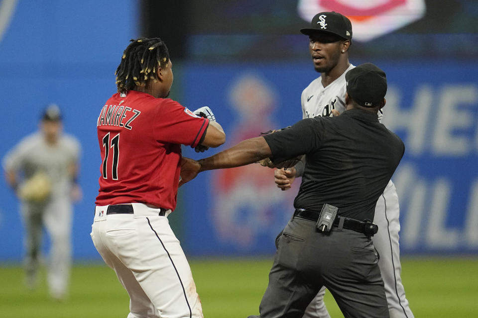 Second base umpire Malachi Moore, front right, gets between Cleveland Guardians' Jose Ramirez (11) and Chicago White Sox's Tim Anderson, back right , in the sixth inning of a baseball game Saturday, Aug. 5, 2023, in Cleveland. (AP Photo/Sue Ogrocki)