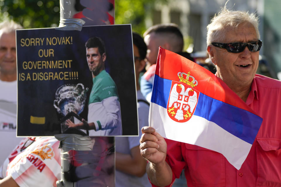 FILE - Supporters of Serbia's Novak Djokovic wait outside the Park Hotel, used as an immigration detention hotel where Djokovic is confined in Melbourne, Australia, Sunday, Jan. 9, 2022. The coronavirus variant has swept across Australia despite its high vaccination rate and strict border policies that kept the country largely sealed off from the world for almost two years. (AP Photo/Mark Baker, File)