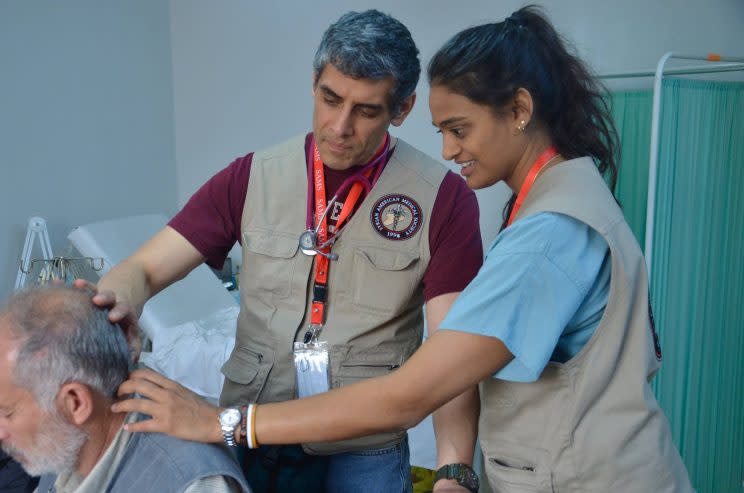 Jihad Shoshara examines a lesion on the back of a refugee’s head after cardiologist Ateka Gunja examined his heart, in Irbid, Jordan, in April 2016. (Photo: Courtesy of Jihad Shoshara)