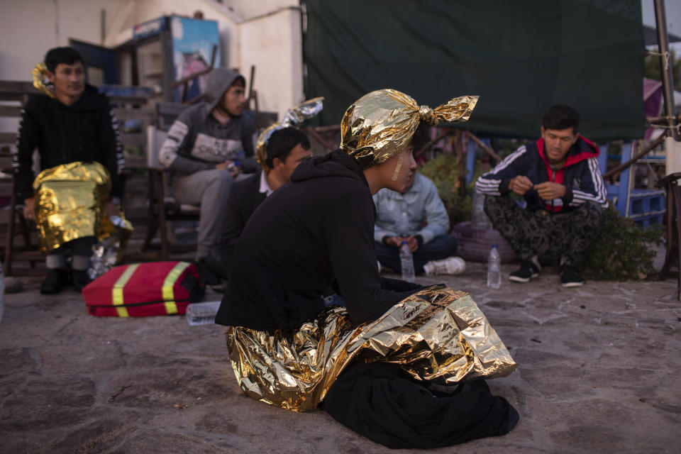 Migrants wearing thermal blankets wait for transport following a rescue operation by a Frontex patrol vessel at the port of Skala Sikamias, on the Greek island of Lesbos, early Thursday, Oct. 3, 2019. Migrants most from Afghanistan were rescued by a Frontex patrol vessel as they were trying to cross a part of the Aegean sea, from Turkey to Greece, on a plastic boat. More than 12,000 people — more than four times the site's capacity — are currently housed in the camp of Moria on Lesbos island and just outside its perimeter following a spike in migrant arrivals over the summer. (AP Photo/Petros Giannakouris)