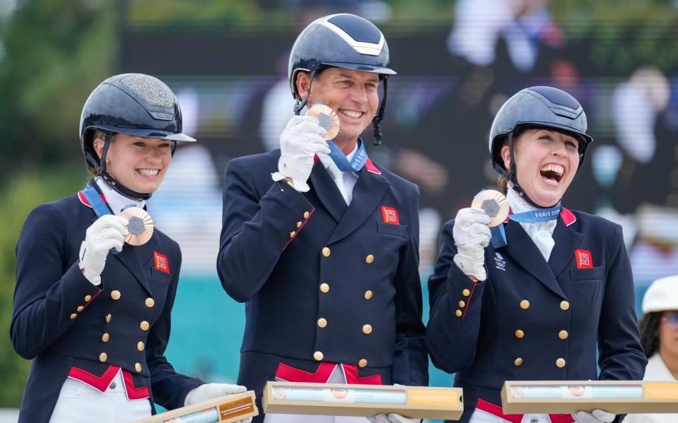 Team Britain, from left to right, Charlotte Fry, Carl Hester and Becky Moody, celebrate their bronze medals at the dressage team Grand Prix final