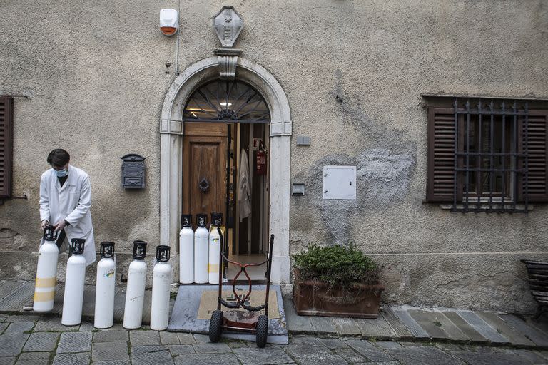 Berti, un farmacéutico local, alinea botes de oxígeno vacíos en la parte trasera de una farmacia para ser reemplazados por otros llenos, en el pueblo toscano de Castellina in Chianti, en Italia, el 17 de diciembre de 2020. Cuesta 10 veces más que entregarlo a granel