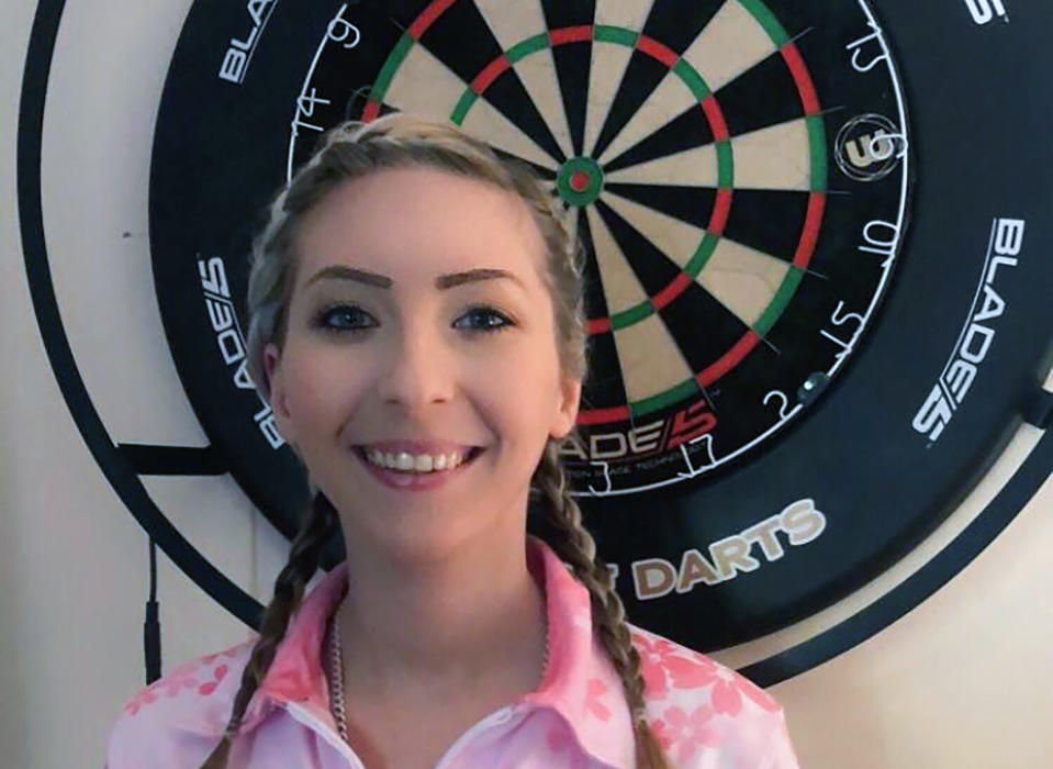 Britain's famed female darts player Fallon Sherrock poses for a photo in Milton Keynes, England, Friday April 24, 2020. Sherrock was the talk of Britain when she became the first woman to beat a man at the darts world championship late last year, breaking down barriers in a game that is usually considered to be a beer-fueled pub game typically played by out-of-shape men. It proved to be a life-changing experience and although on lockdown now because of the coronavirus she will regularly play in men's events, Sherrock tells The Associated Press Friday April 24, 2020. (Sue Sherrock via AP)