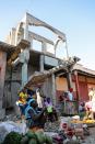 Merchants wait for customers at a street market in Jean-Rebel