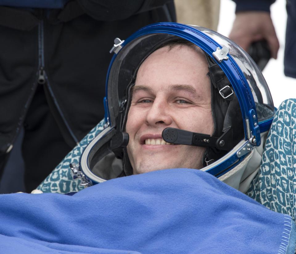 Flight engineer Sergei Ryazansky sits in a chair outside the Soyuz TMA-10M capsule shortly after the landing in a remote area southeast of the town of Zhezkazgan in central Kazakhstan, March 11, 2014. (REUTERS/Bill Ingalls/NASA/Handout via Reuters)