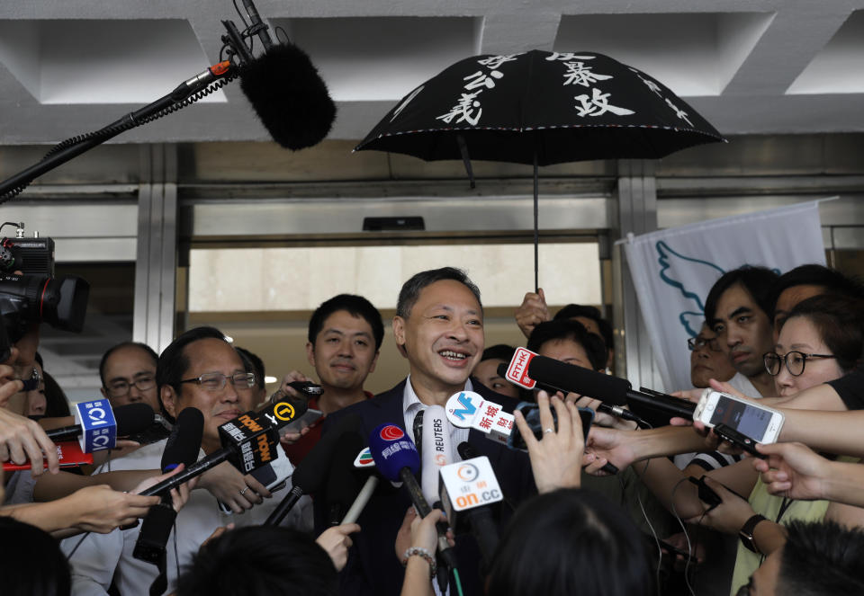 Occupy Central leader Benny Tai, center, talks to reporters outside the High court in Hong Kong Thursday, Aug.15, 2019. Tai, a top opposition leader imprisoned on public disorder charges was released on bail Thursday as Hong Kong's government attempts to quell a protest movement that has paralyzed parts of the territory, including its international airport, and led to hundreds of arrests. (AP Photo/Vincent Yu)