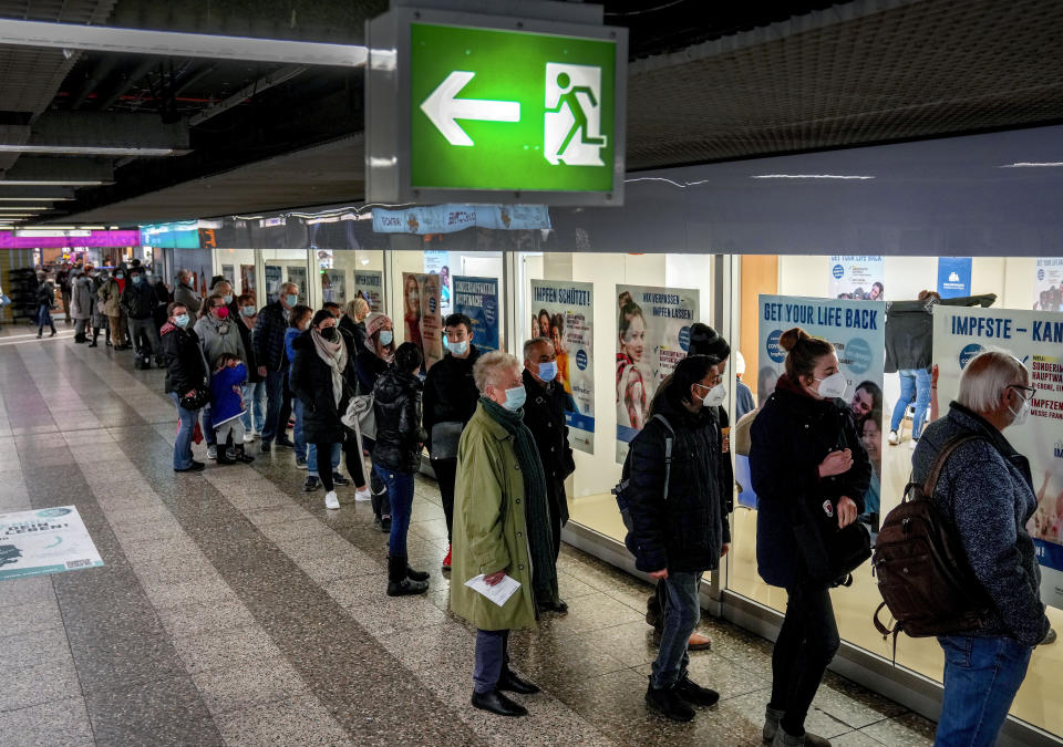 FILE - People queue in front of a small vaccination center of the local health department in Frankfurt, Germany, Monday, Nov. 15, 2021. The numbers of Corona infections have been rising again in Germany. (AP Photo/Michael Probst, File)