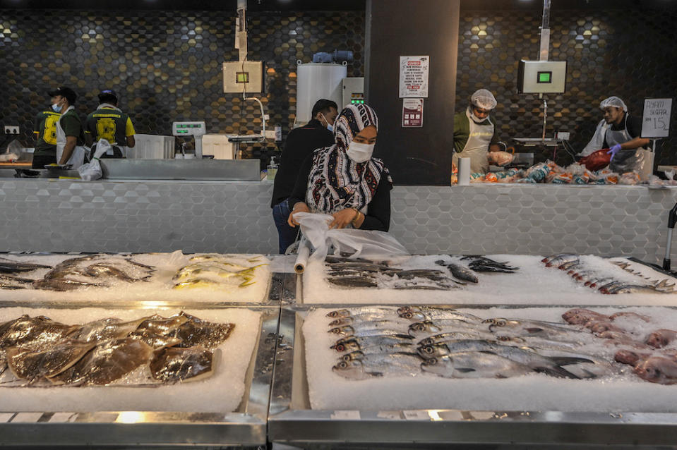 A customer selecting fish at a supermarket in Cyberjaya April 5, 2020. — Picture by Shafwan Zaidon