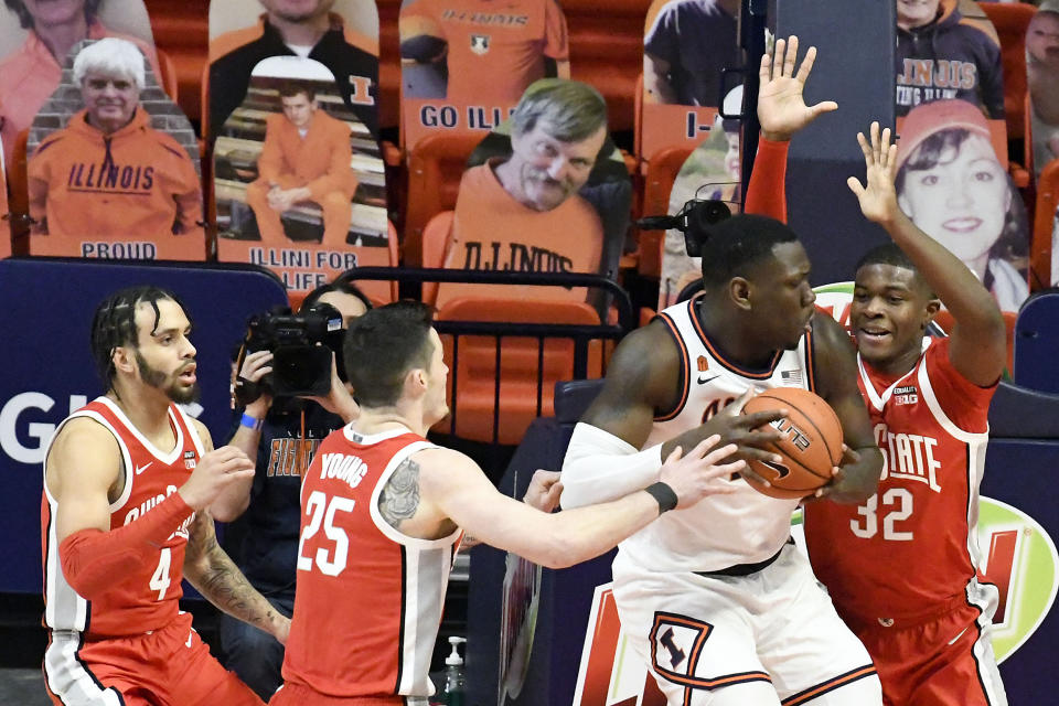 Illinois center Kofi Cockburn (21) is pressured by Ohio State's guard Duane Washington Jr. (4), forward Kyle Young (25) and forward E.J. Liddell (32) during the first half of an NCAA college basketball game Saturday, Jan. 16, 2021, in Champaign, Ill. (AP Photo/Holly Hart)