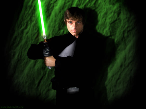 Luke Skywalker holds a light saber.