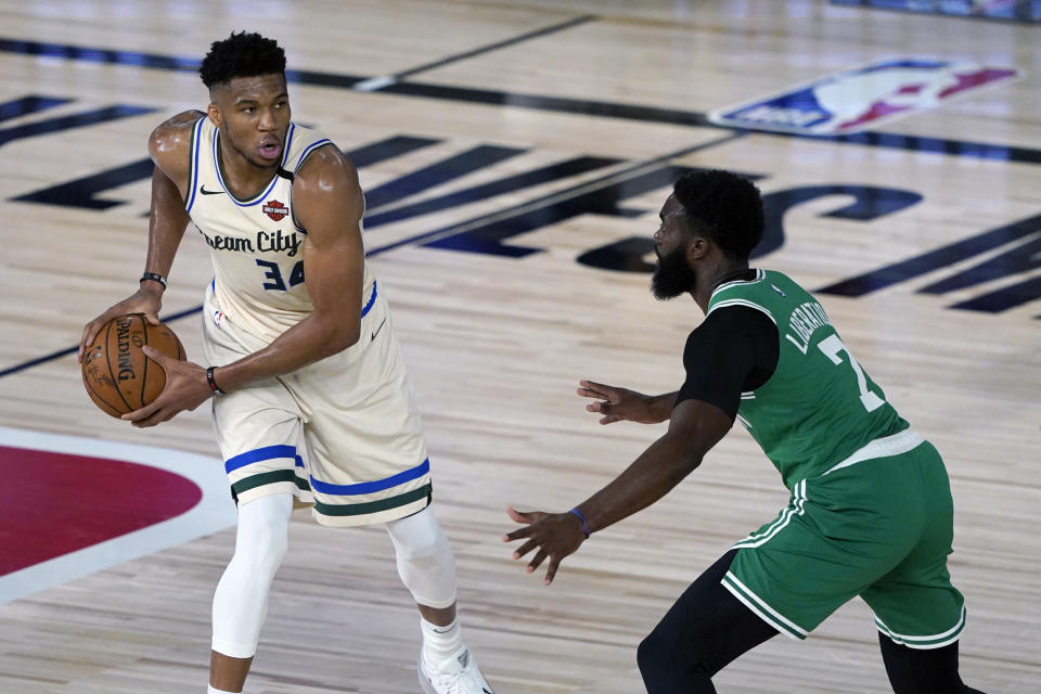 Milwaukee Bucks' Giannis Antetokounmpo (34) looks to pass around Boston Celtics' Jaylen Brown (7) during the first half of an NBA basketball game Friday, July 31, 2020, in Lake Buena Vista, Fla. (AP Photo/Ashley Landis, Pool)