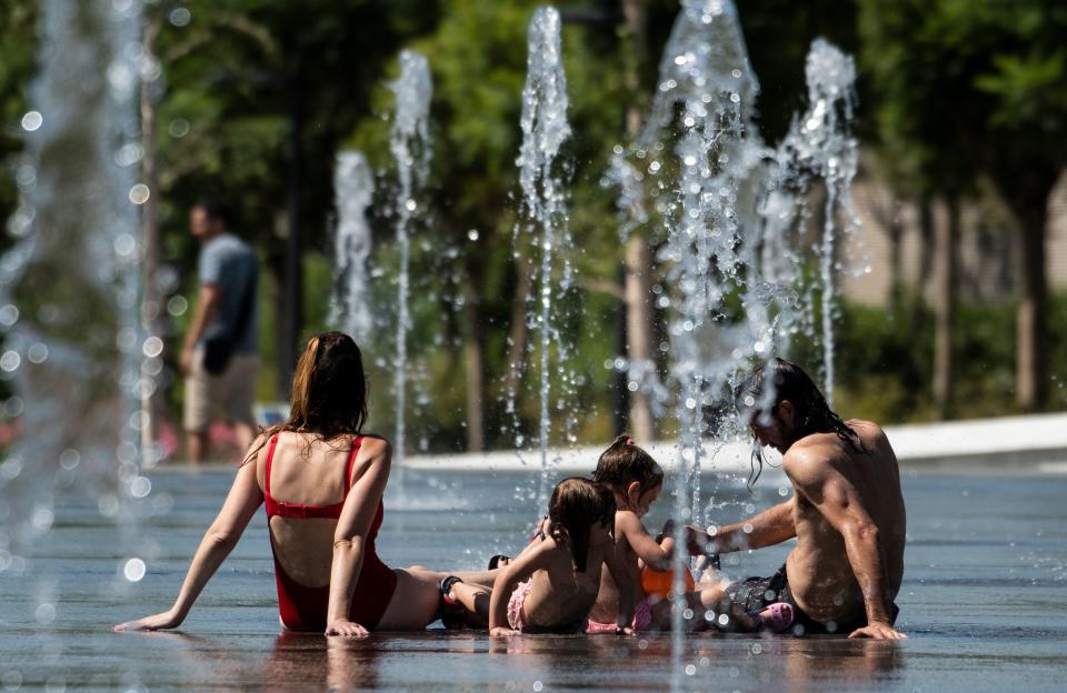 Una familia se baña en una fuente de Valencia durante la última ola de calor que ha golpeado a España. Foto: JOSE JORDAN/AFP/Getty Images.