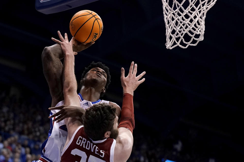 Kansas forward K.J. Adams Jr., back, shoots over Oklahoma forward Tanner Groves (35) during the first half of an NCAA college basketball game Tuesday, Jan. 10, 2023, in Lawrence, Kan. (AP Photo/Charlie Riedel)