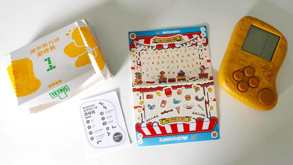Mcdonalds Mcnugget handheld with extra stickers, instructions, and box sitting on white desk
