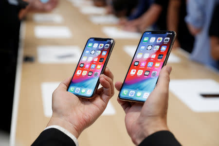 FILE PHOTO: A man holds the newly released Apple iPhone XS and XS Max during a product demonstration following the Apple launch event at the Steve Jobs Theater in Cupertino, California, U.S. September 12, 2018. REUTERS/Stephen Lam/File Photo