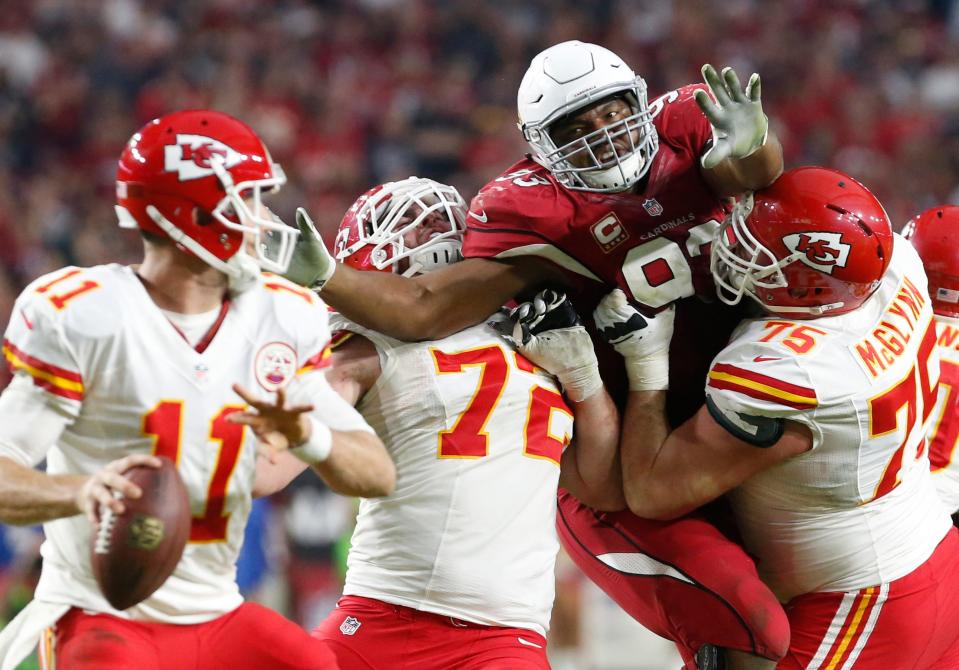 In this 2014 photo, Arizona Cardinals DE Calais Campbell splits the block by Kansas City Chiefs linemen Eric Fisher (72) and Mike McGlynn (75) to pressure QB Alex Smith (11)