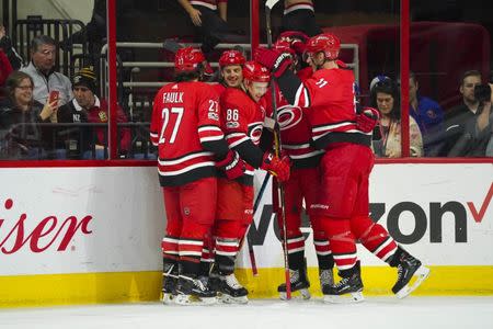 Nov 19, 2017; Raleigh, NC, USA; Carolina Hurricanes forward Teuvo Teravainen (86) celebrates his first period goal with teammates defensemen Justin Faulk (27) forward Jordan Staal (11) and forward Sebastian Aho (20) against the New York Islanders at PNC Arena. The Carolina Hurricanes defeated the New York Islanders 4-2. James Guillory-USA TODAY Sports