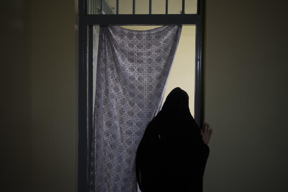 An Afghan woman walks out of a cell inside the women's section of the Pul-e-Charkhi prison in Kabul, Afghanistan, Thursday, Sept. 23, 2021. When the Taliban took control of a northern Afghan city of Pul-e-Kumri the operator of the only women's shelter ran away, abandoning 20 women in it. When the Taliban arrived at the shelter the women were given two choices: Return to their abusive families, or go with the Taliban, With nowhere to put the women, the Taliban took them to the abandoned women's section of Afghanistan's notorious Pul-e-Charkhi prison. (AP Photo/Felipe Dana)