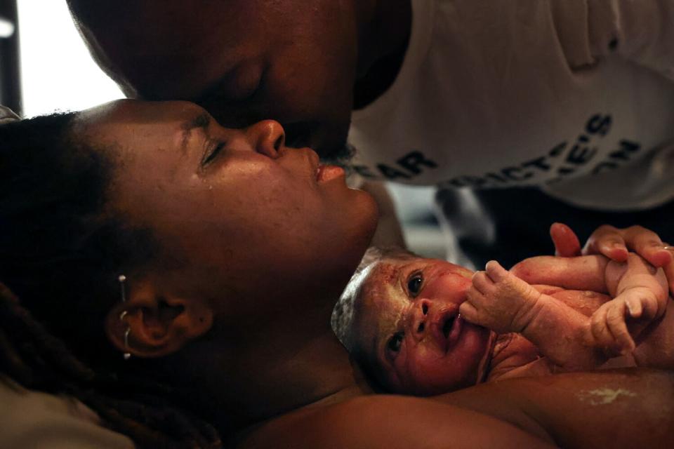 May 28: Ashanique Nelson-Cavil holds her baby girl moments after her birth while a man is nearby.