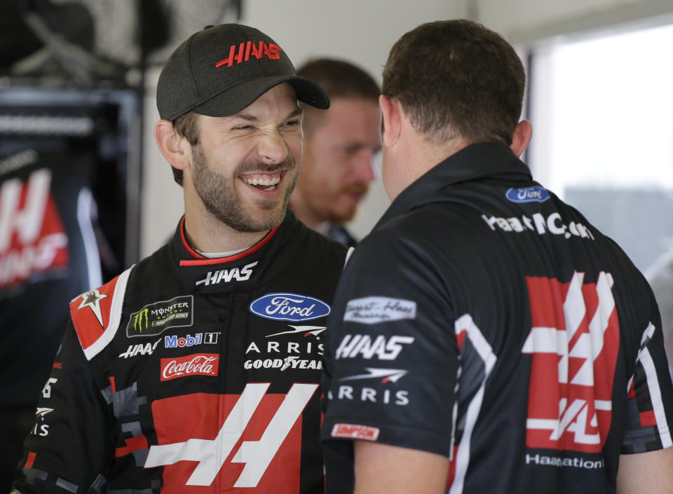 Daniel Suarez, left, laughs with crew members in his garage during a NASCAR auto race practice at Daytona International Speedway, Thursday, July 4, 2019, in Daytona Beach, Fla. (AP Photo/Terry Renna)