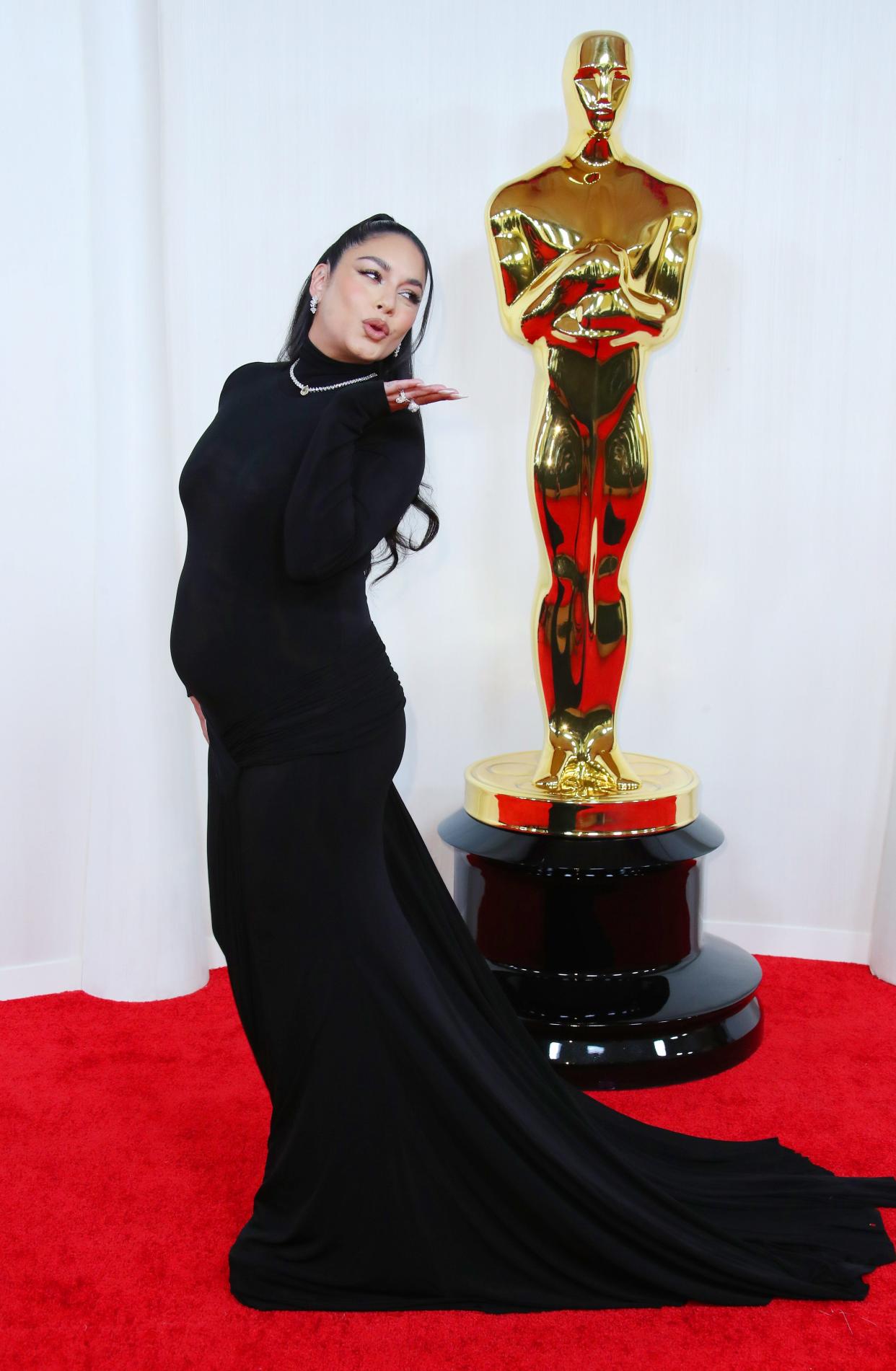 An expecting Vanessa Hudgens blows a kiss as she shows off her bump.
