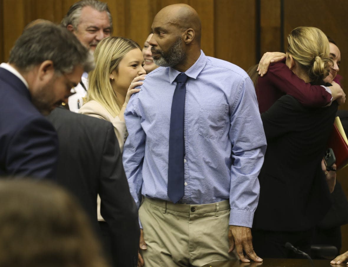 Lamar Johnson, center looks toward friends and family members as his attorneys celebrate on Tuesday, Feb. 14, 2023, after St. Louis Circuit Judge David Mason vacated his murder conviction during a hearing in St. Louis, Mo. (Christian Gooden/St. Louis Post-Dispatch via AP, Pool)